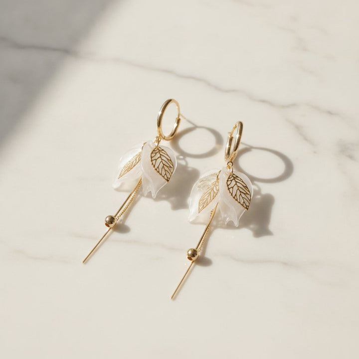Pendientes colgantes elegantes de oro con pétalos blancos y circonia