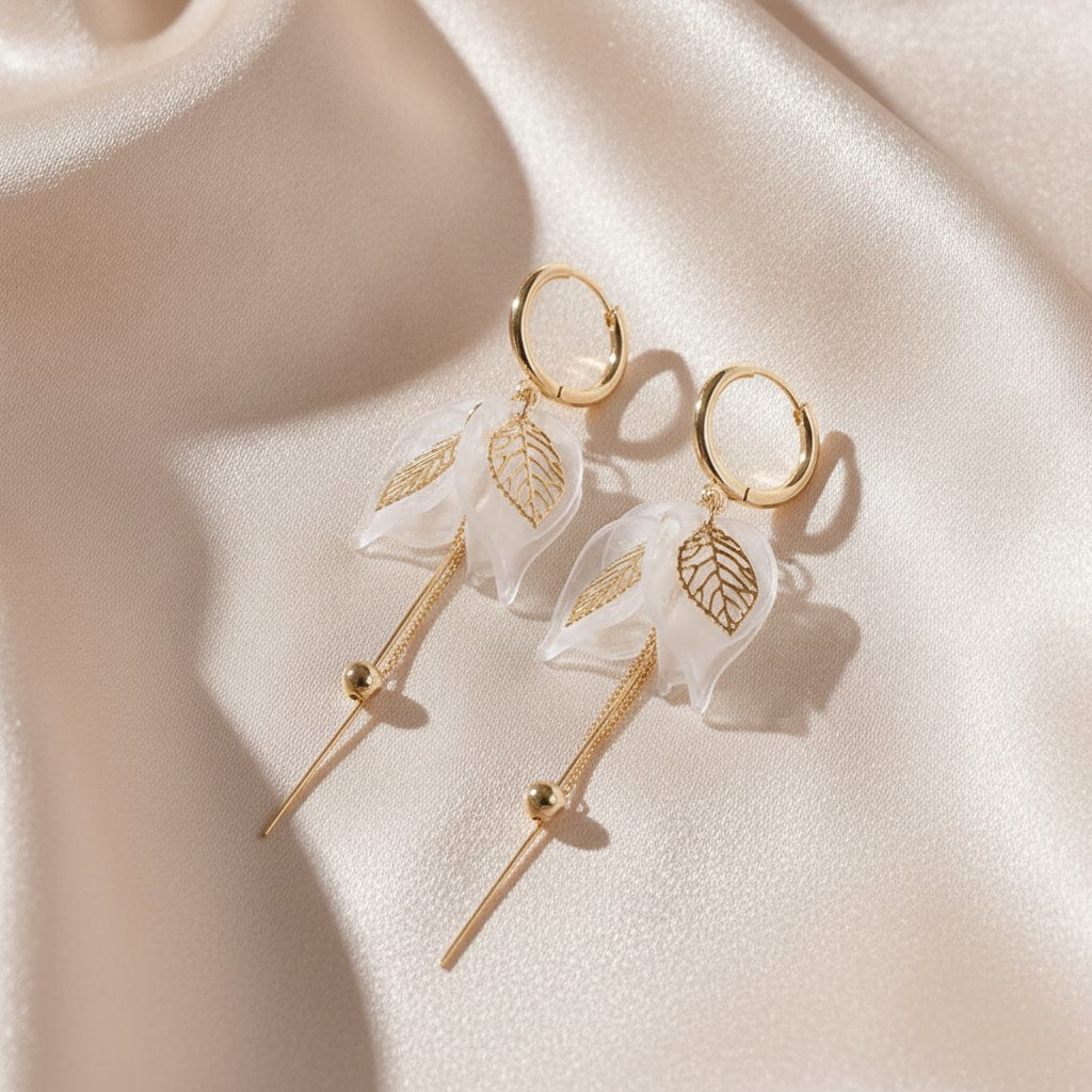 Pendientes colgantes elegantes de oro con pétalos blancos y circonia